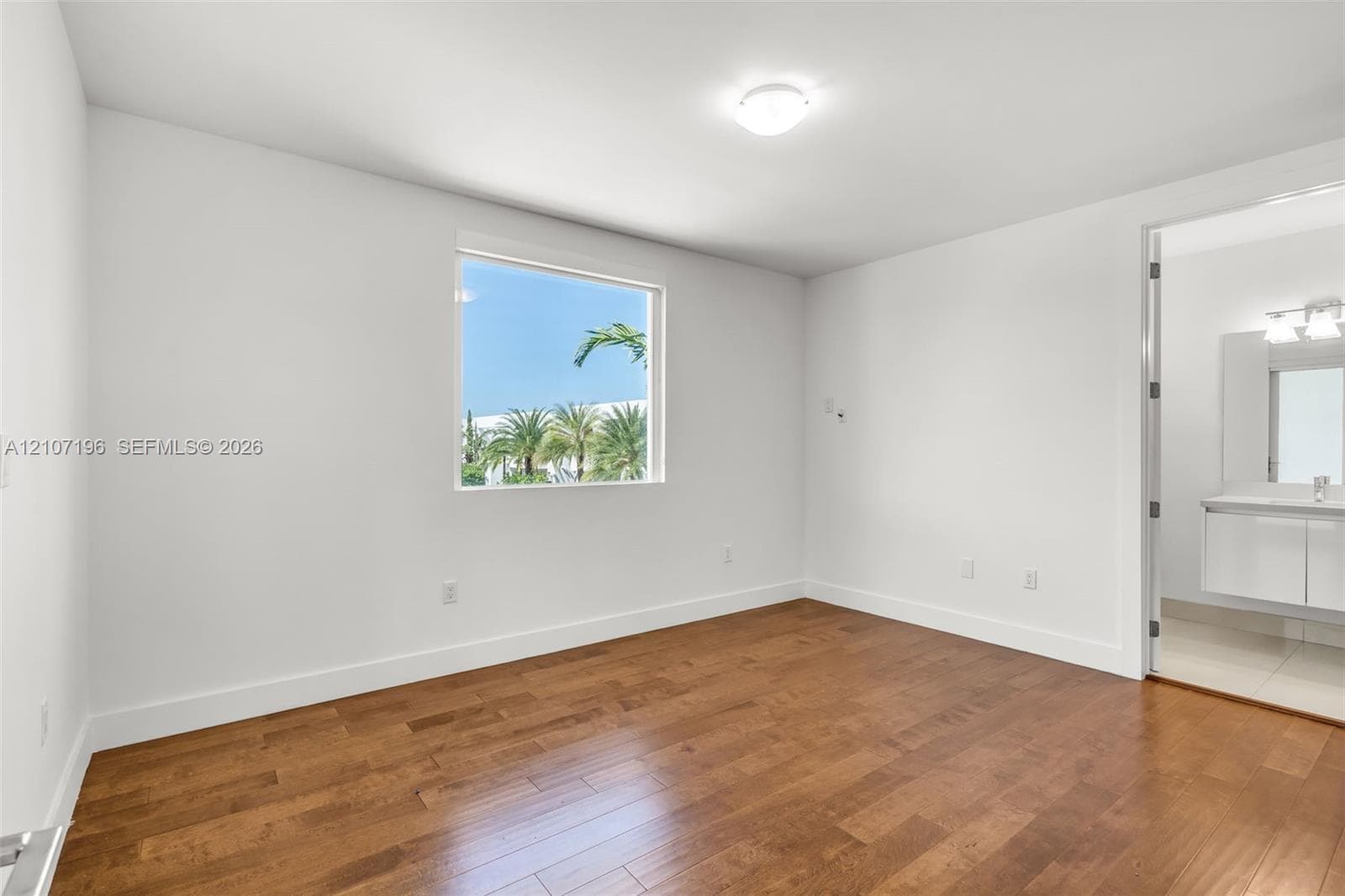 Room featuring wood-finish flooring, a large window, neutral wall paint, and recessed ceiling lighting
