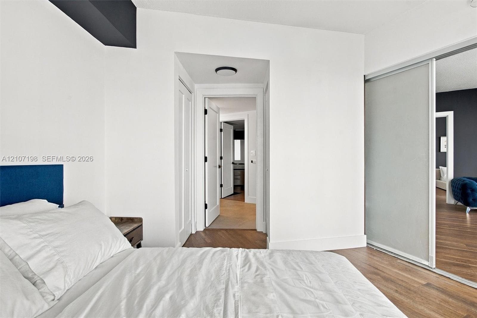 Covered balcony featuring concrete flooring, a curved metal railing, and floor-to-ceiling glass panel doors