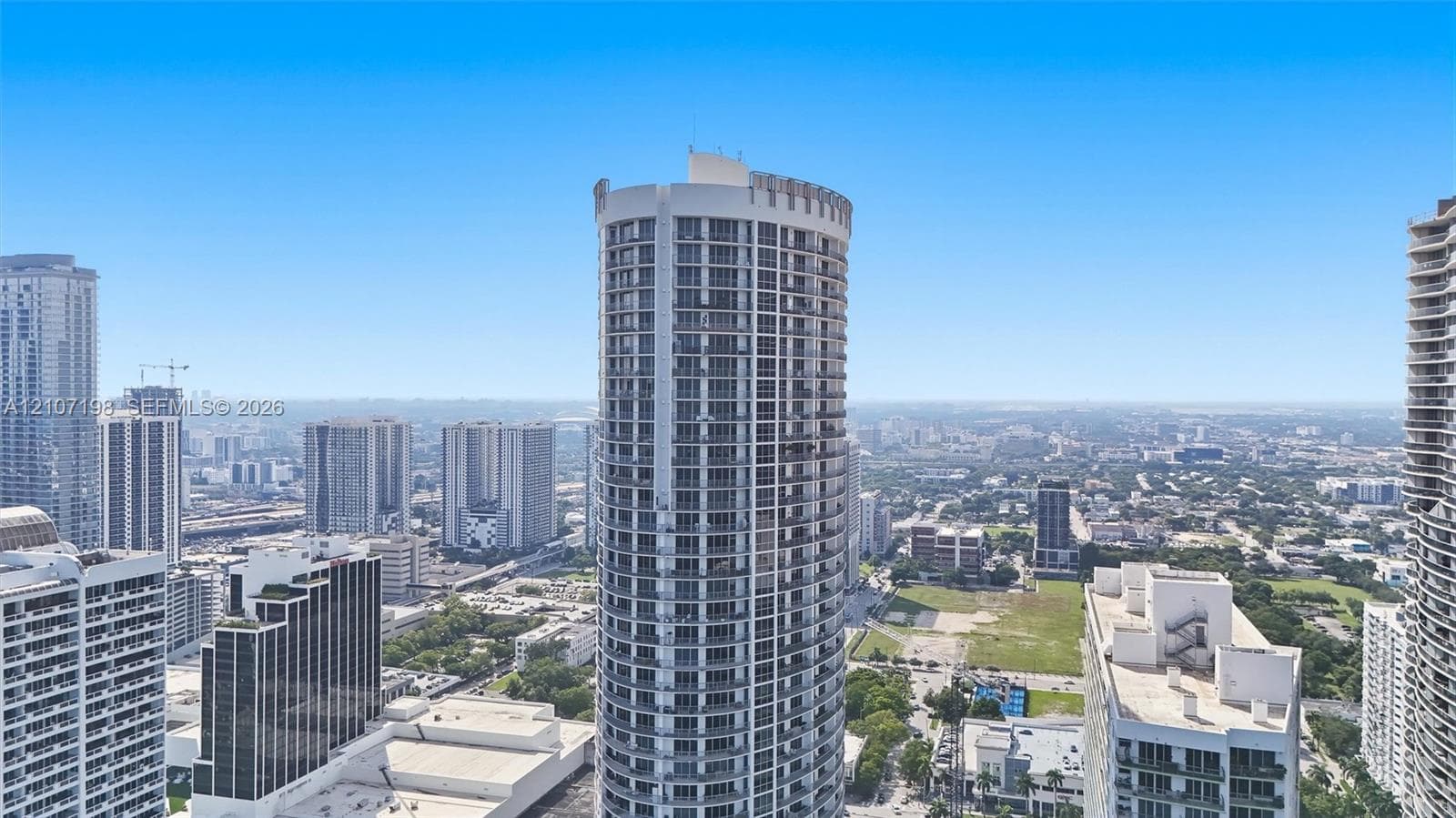 Floor-to-ceiling windows, wood-finish flooring, and direct access to an exterior balcony