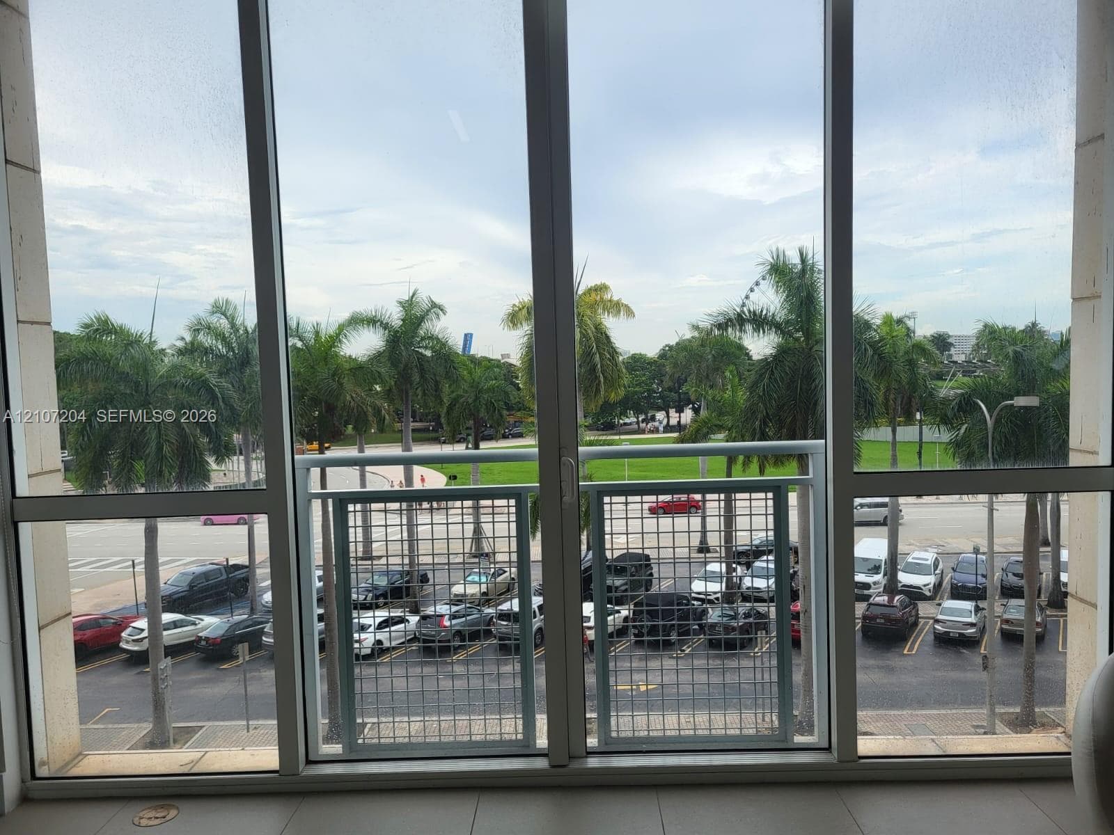 Floor-to-ceiling windows featuring a white metal grid balcony railing