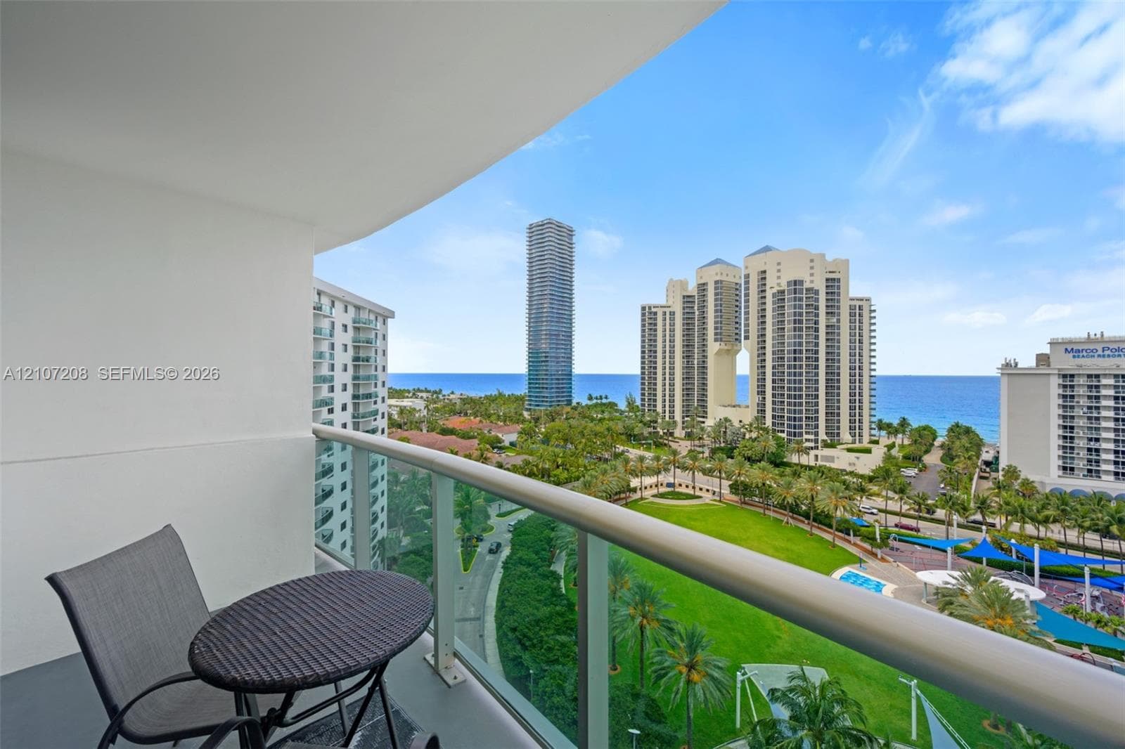 Private balcony with glass panel railing and painted concrete flooring