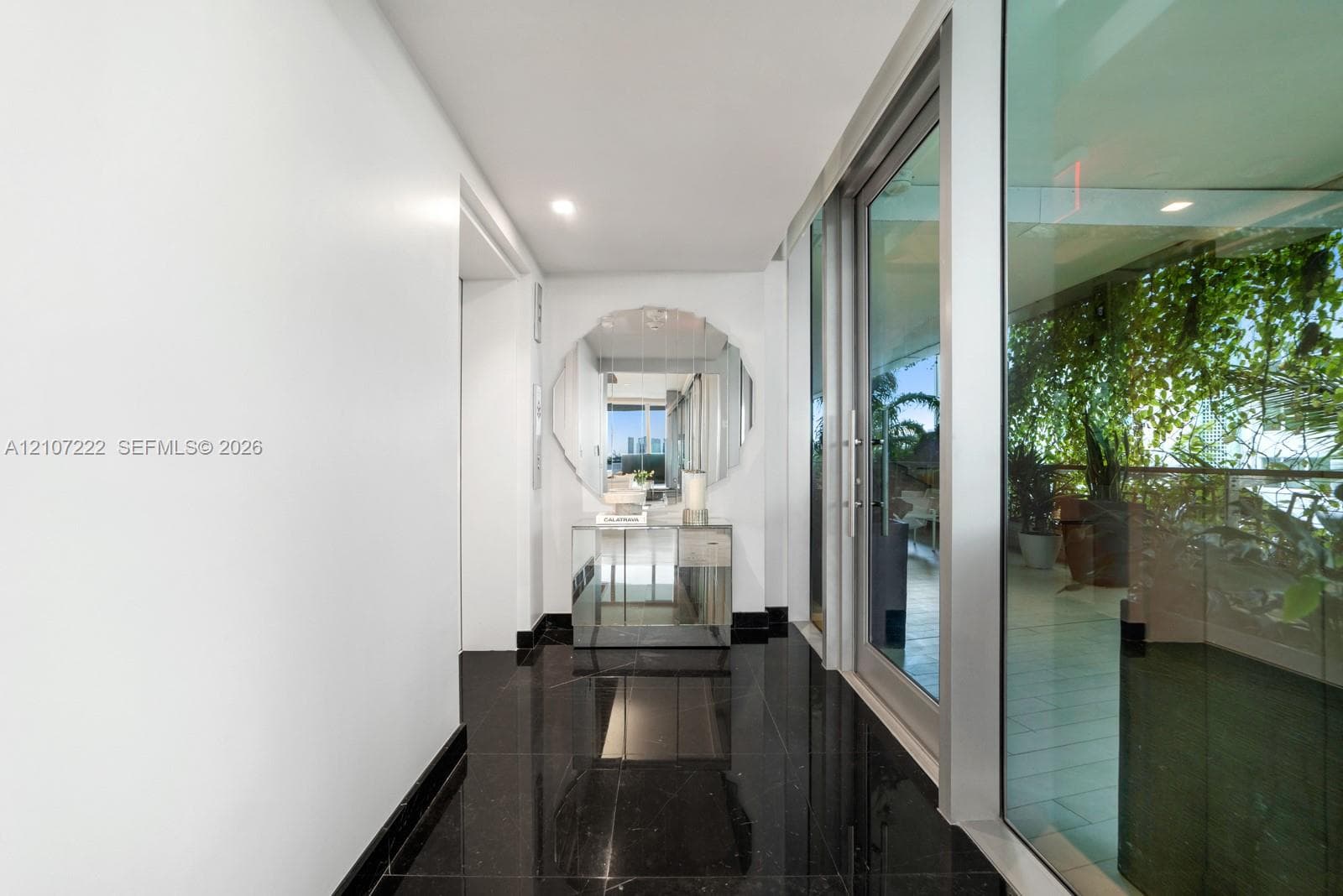 Foyer featuring polished black stone flooring, recessed lighting, and expansive floor-to-ceiling glass paneling