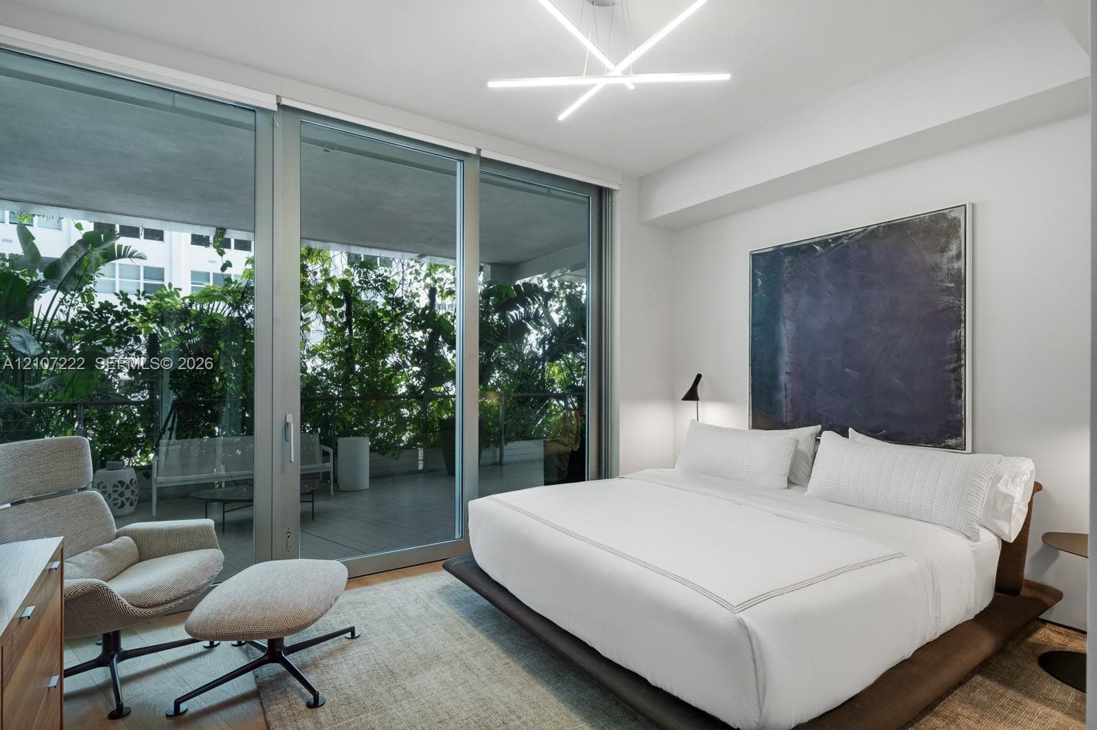 Floor-to-ceiling sliding glass panels, private balcony, contemporary geometric chandelier, and neutral wall finish