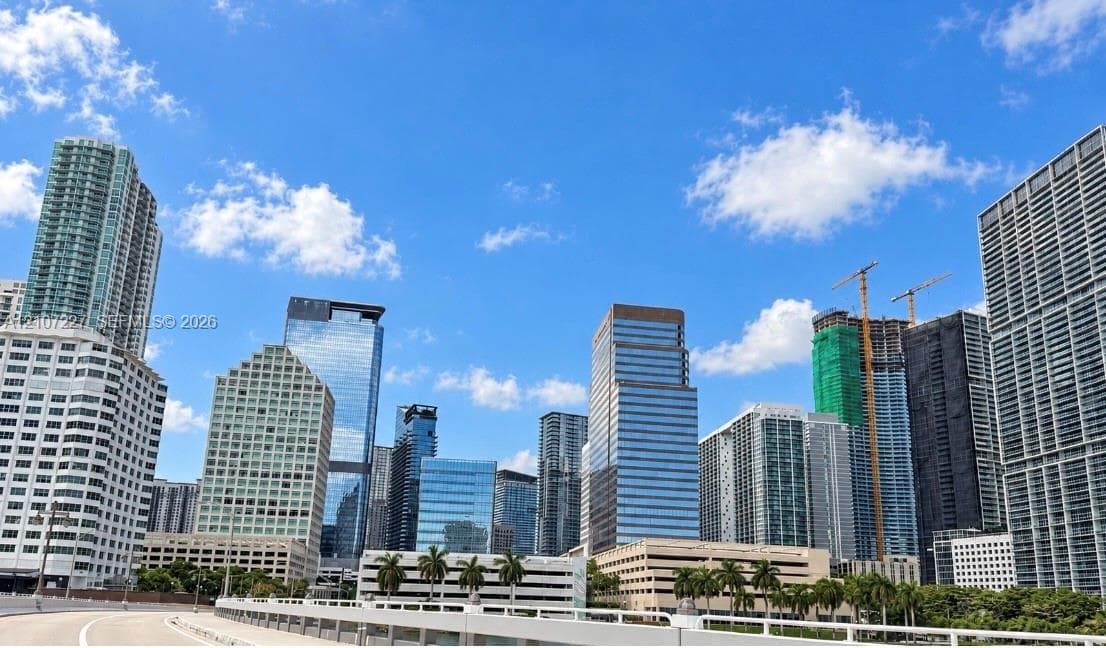 Urban cityscape featuring high-rise glass towers and concrete commercial architecture under a clear sky