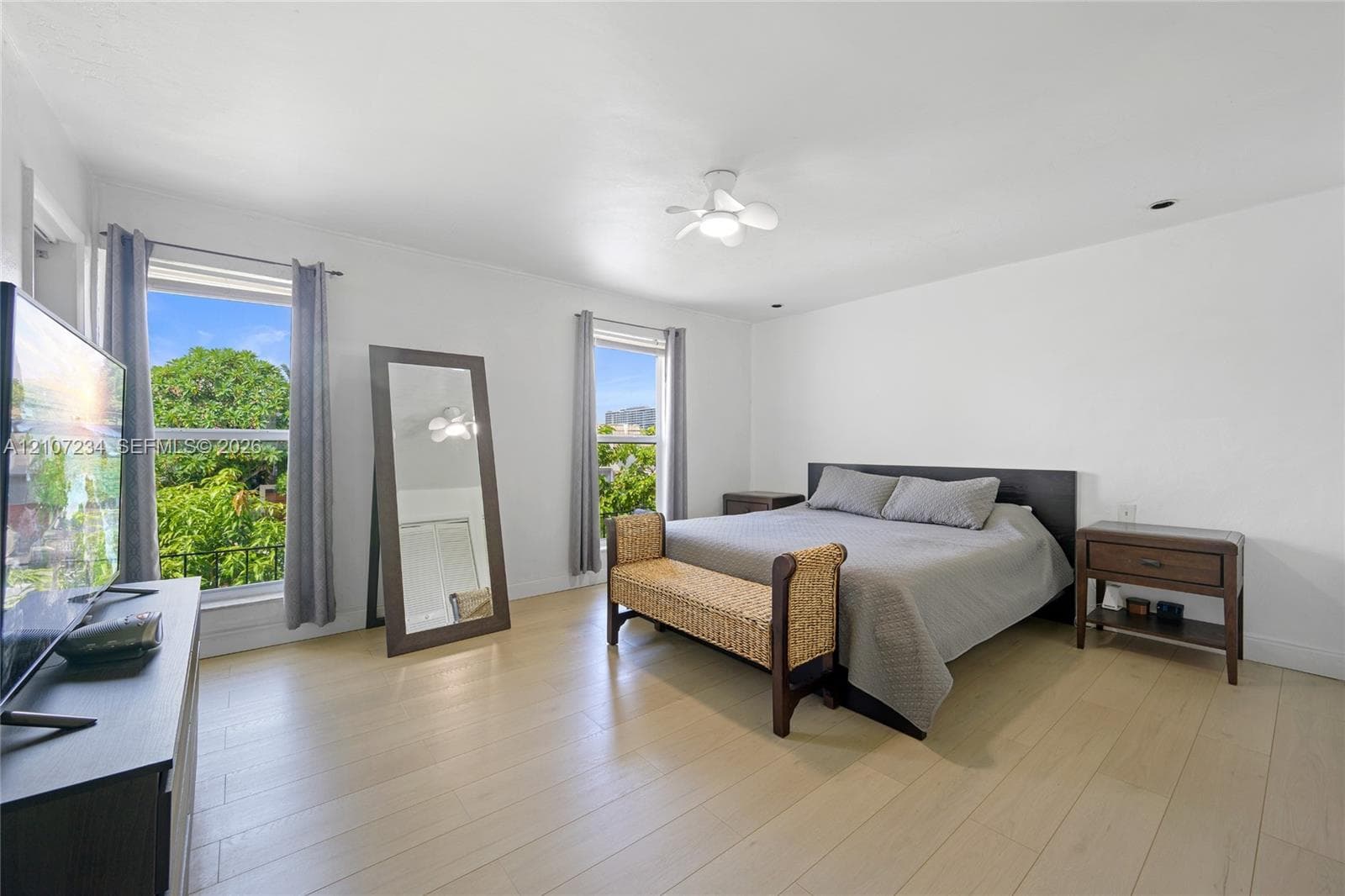 Neutral interior space featuring wood-finish flooring, dual windows, and a ceiling-mounted light fixture