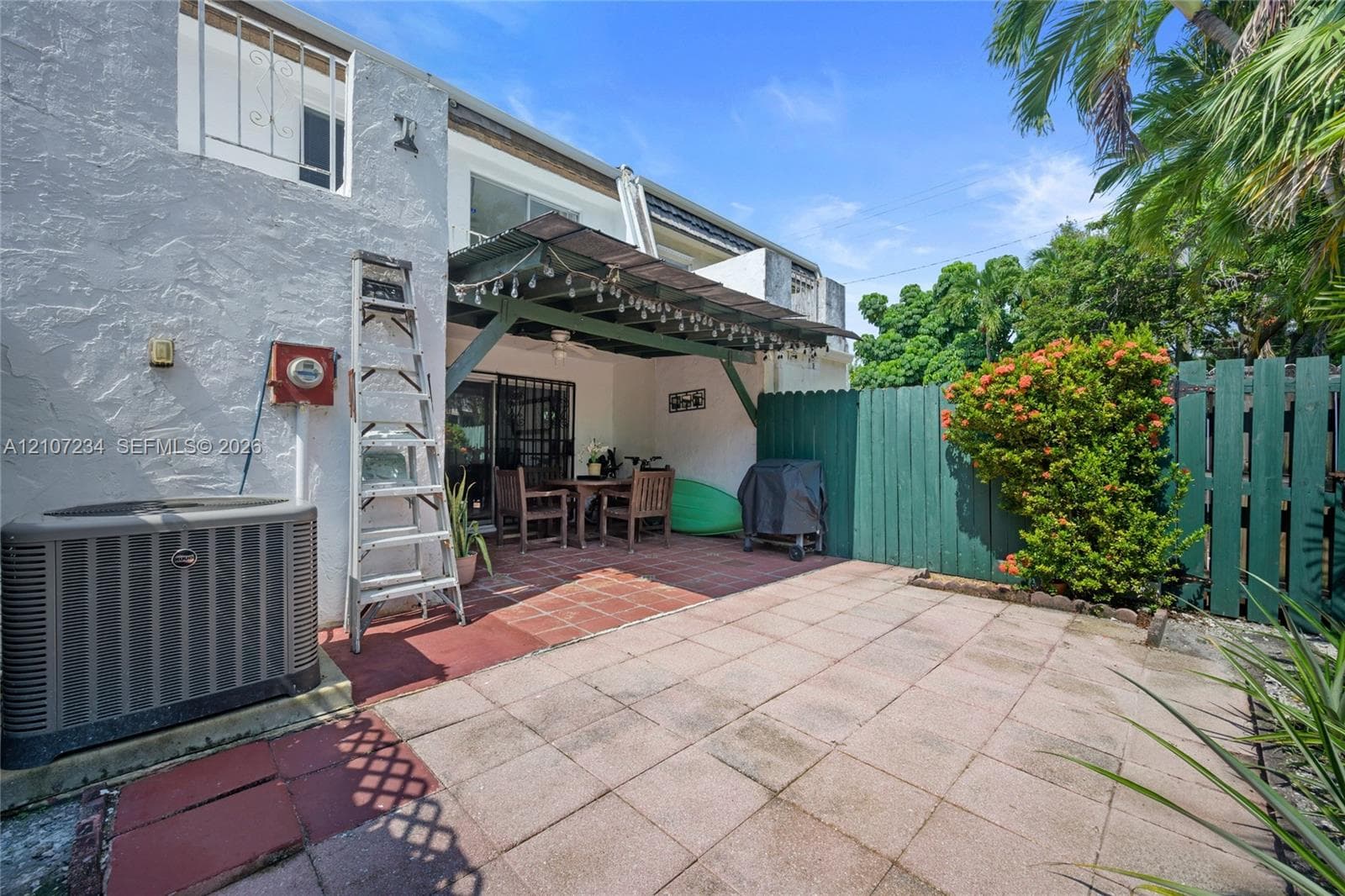 Private patio with concrete paver flooring, covered pergola, and privacy fencing