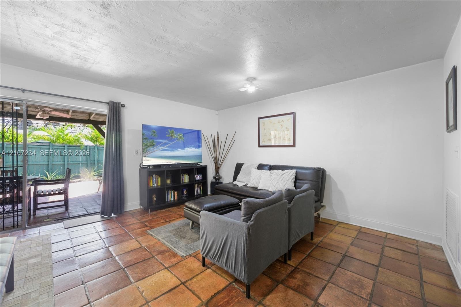 Ceramic tile flooring, sliding glass door, and white walls
