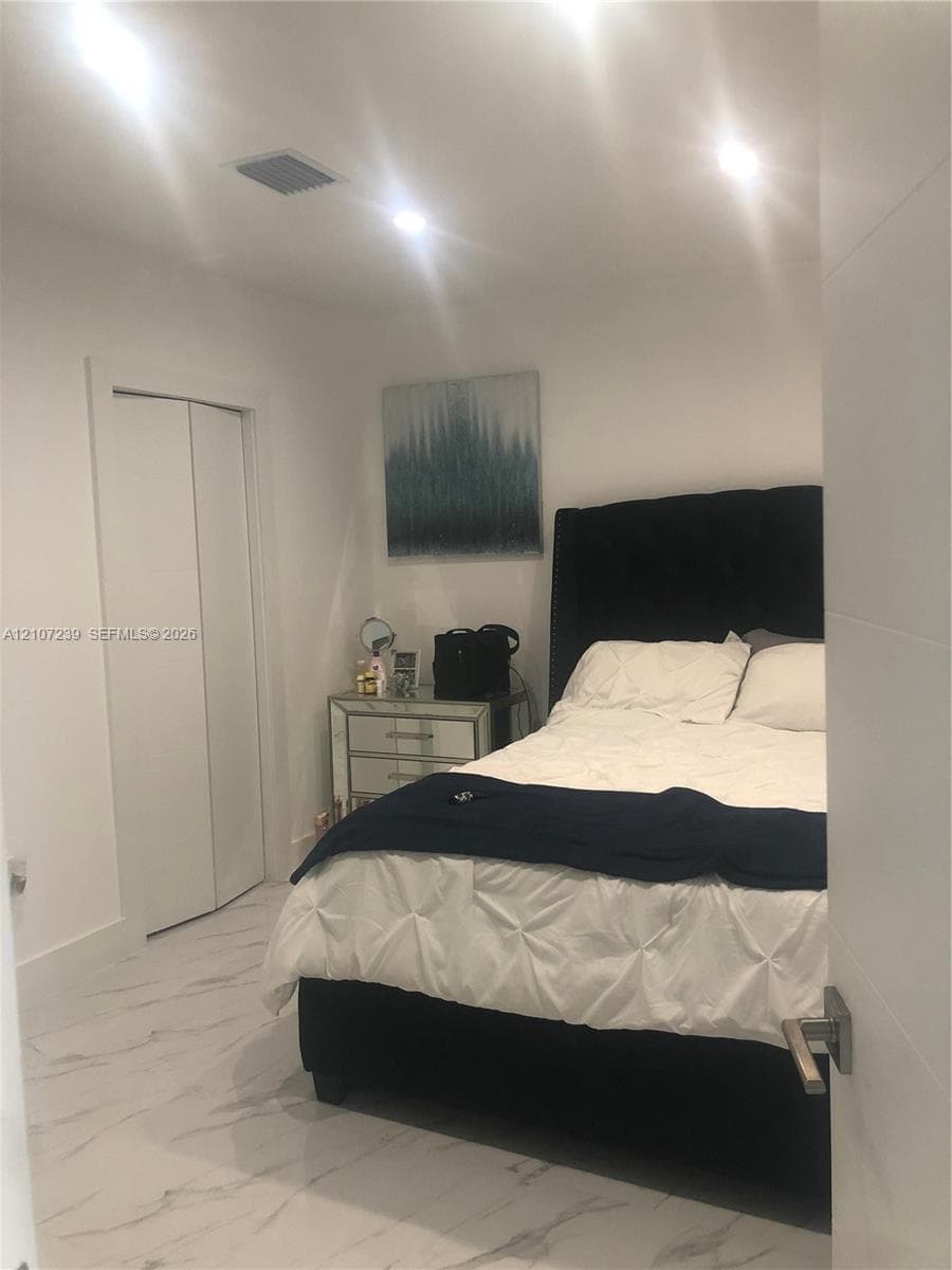 Interior room featuring stone-finish tile flooring, recessed ceiling lighting, and a bi-fold closet door