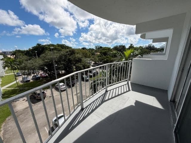 Private balcony featuring a concrete surface and a white metal railing