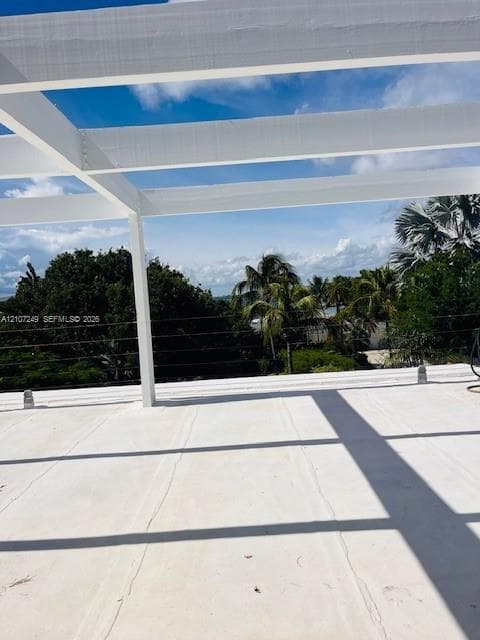Rooftop terrace featuring a white pergola structure, smooth composite flooring, and horizontal cable railing