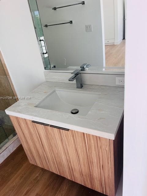 Modern bathroom vanity featuring a wood-finish cabinet with integrated rectangular vessel sink, light stone countertop, and contemporary matte black faucet