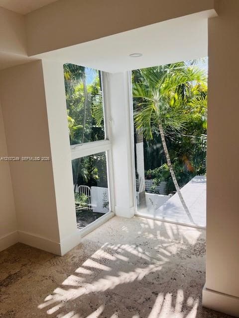 Corner alcove with floor-to-ceiling windows, natural stone flooring, and recessed ceiling lighting