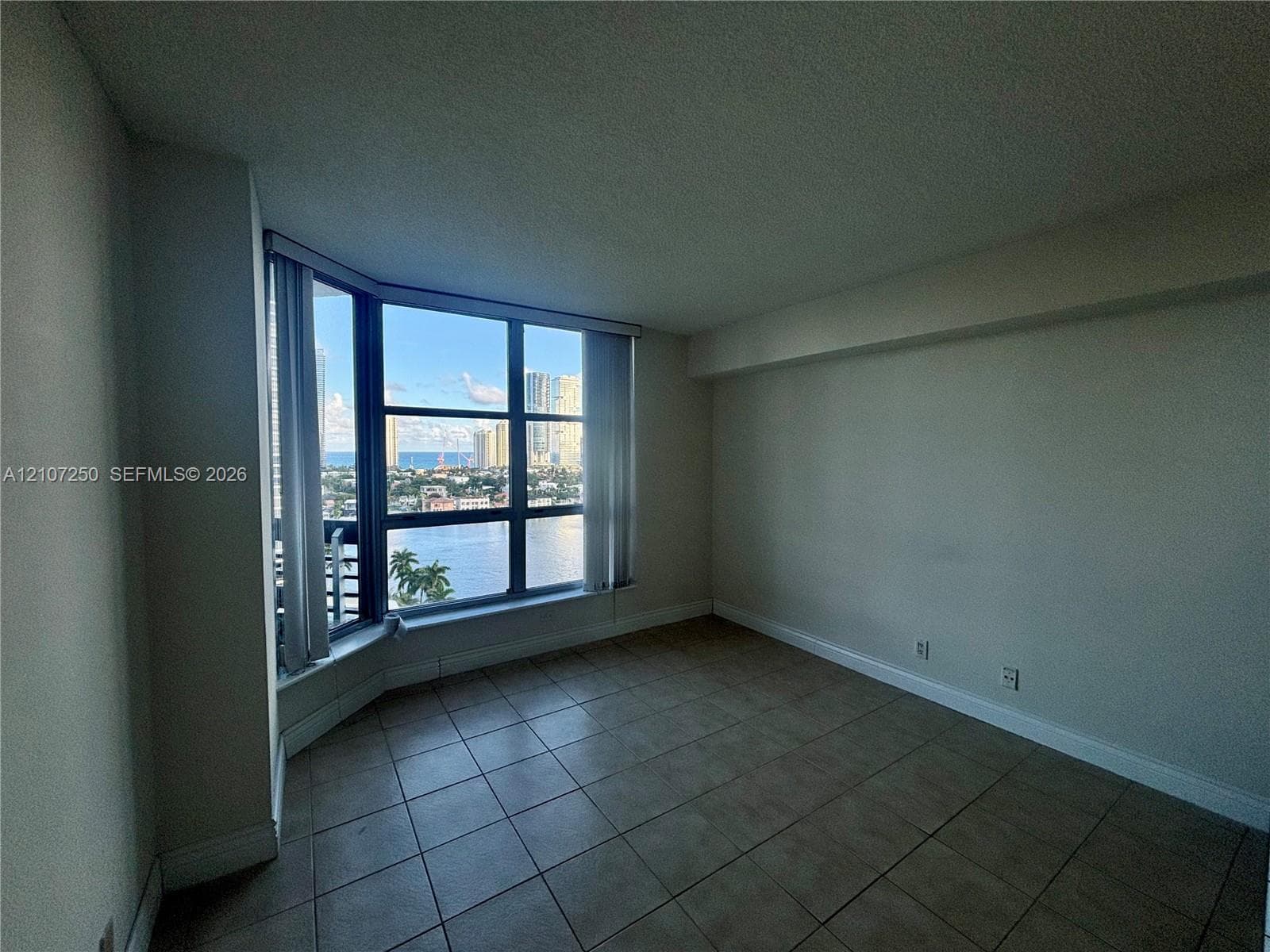 Large-format bay window, floor-to-ceiling glass, tile flooring, neutral wall finishes