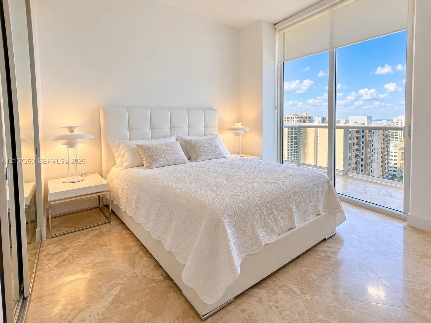 Floor-to-ceiling sliding glass doors, polished stone flooring, and mirrored closet doors