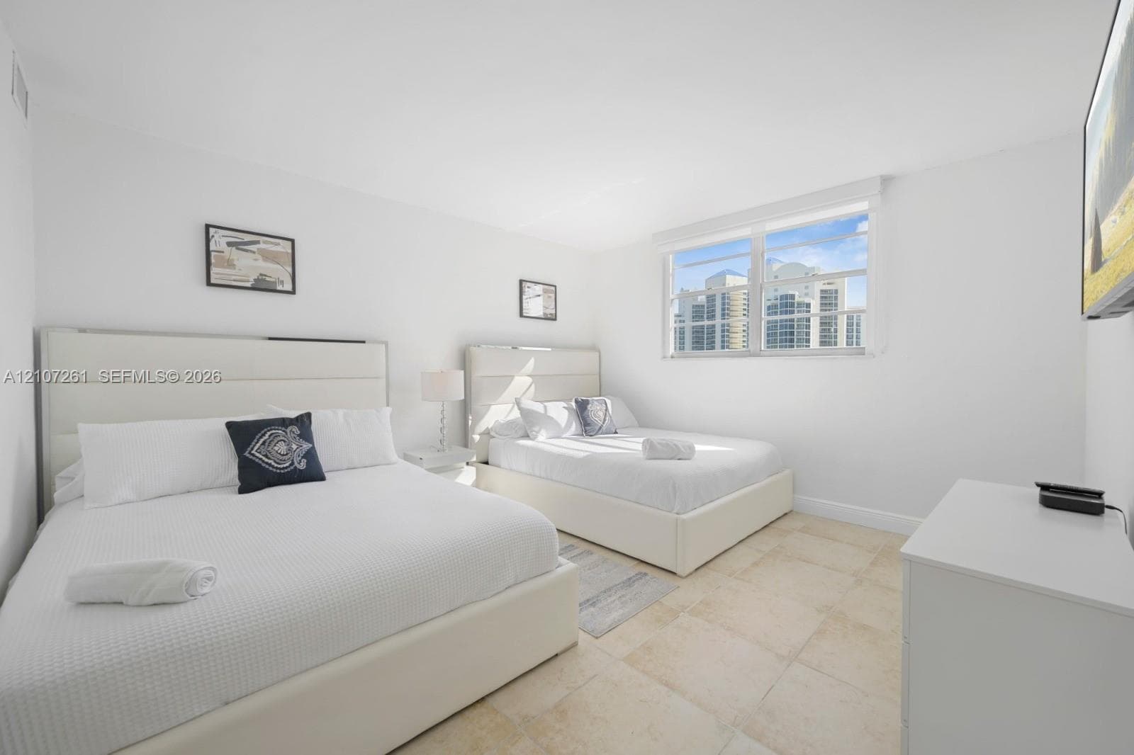 Neutral-toned tile flooring, large multi-pane windows, and minimalist wall finishes