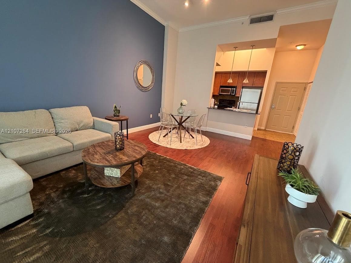 High ceilings with recessed lighting, wood-finish flooring, and a kitchen featuring a breakfast bar and wooden cabinetry