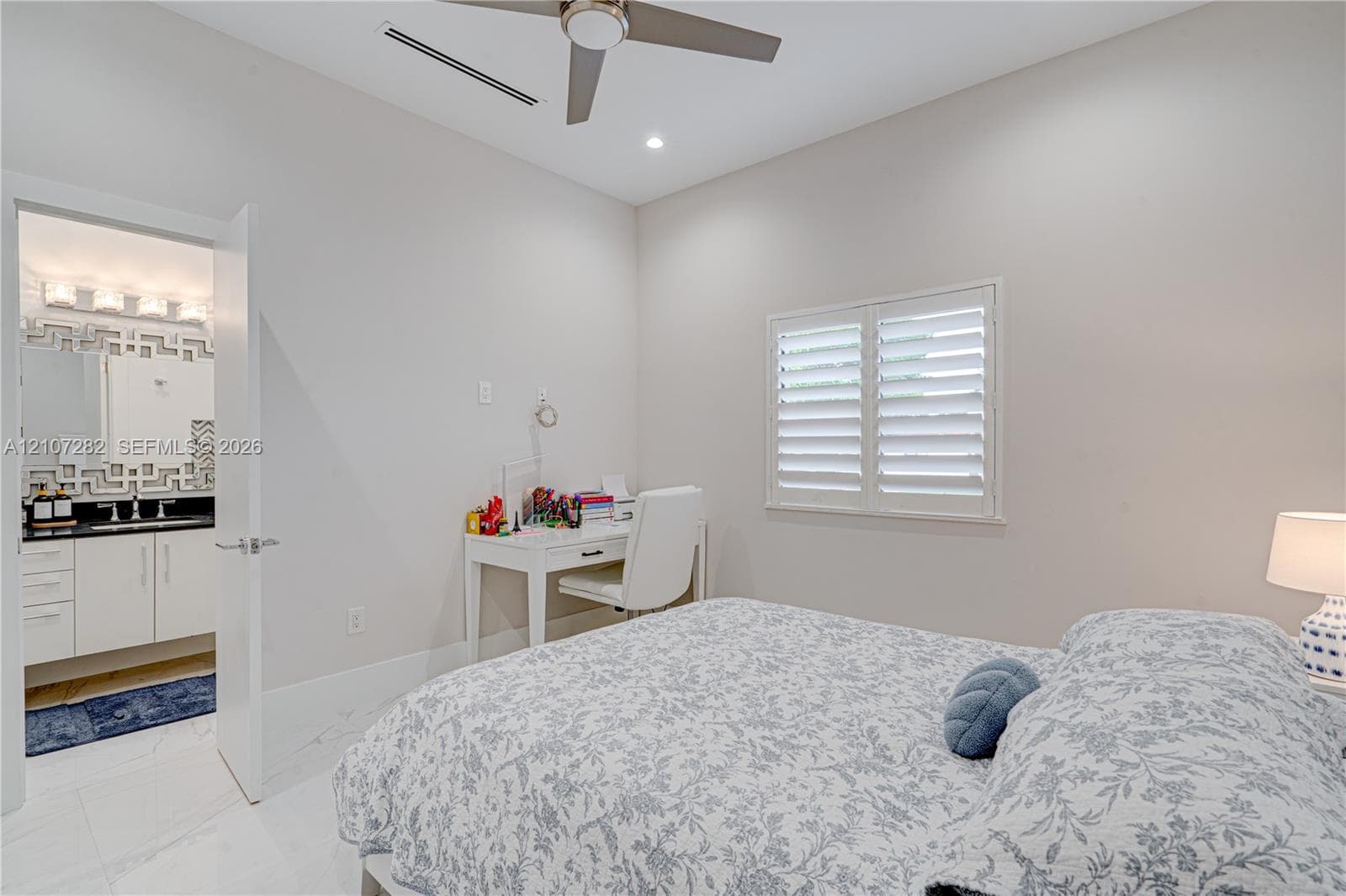 Room featuring white tile flooring, ceiling fan, recessed lighting, plantation shutters, and a bathroom with white cabinetry and a dark countertop
