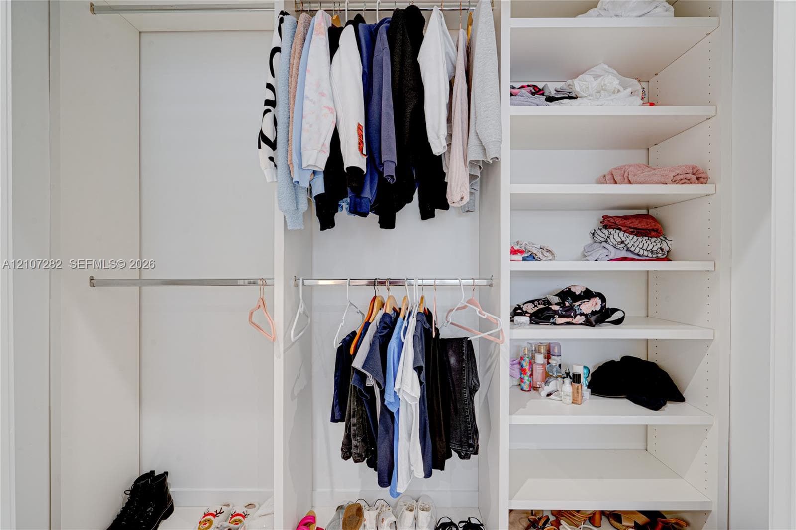 Built-in white storage cabinetry featuring adjustable shelving, integrated metal hanging rods, and a modular configuration