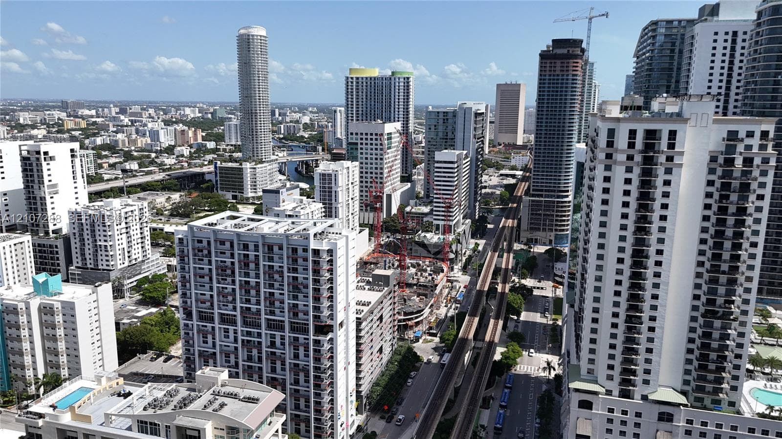 High-rise urban landscape featuring numerous multi-story residential towers, dense metropolitan architecture, and an elevated transit corridor