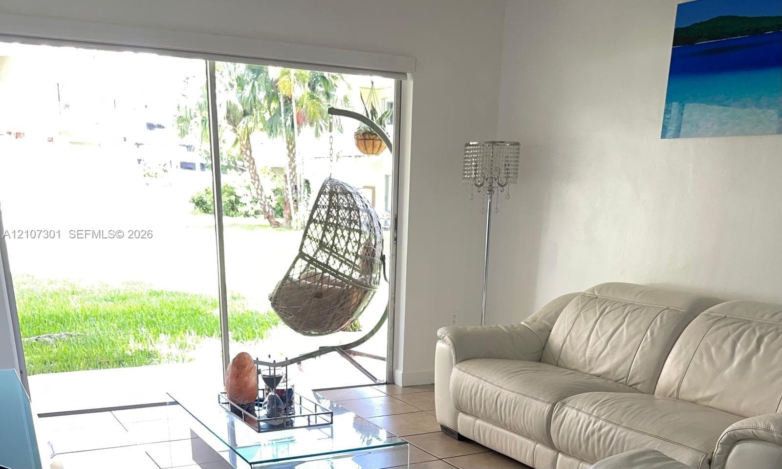 Floor-to-ceiling sliding glass door with ceramic tile flooring