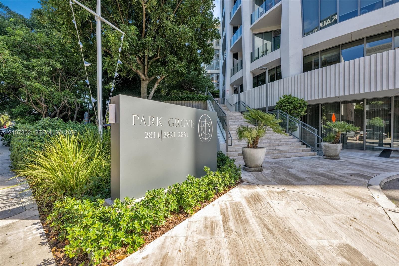 Exterior entrance featuring stone staircases, paved stone grounds, and manicured perimeter landscaping