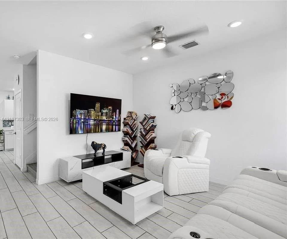 Covered concrete patio featuring a perimeter wood privacy fence, mounted outdoor fan, and integrated storage unit