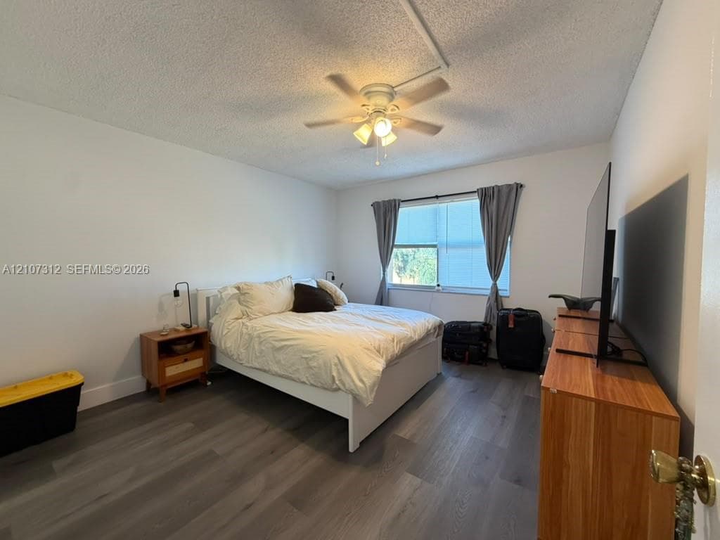 Wood-finish flooring, ceiling fan with integrated lighting, and window providing natural light
