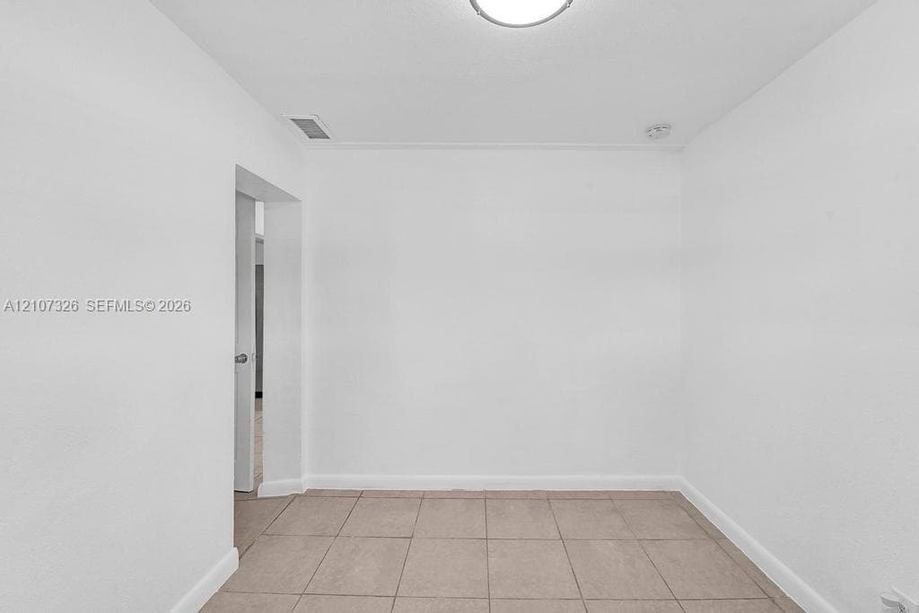 Neutral interior space featuring smooth wall finishes and large-format tile flooring