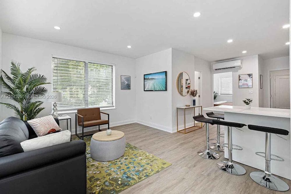Open-concept living room with modern kitchen and wood-look flooring.