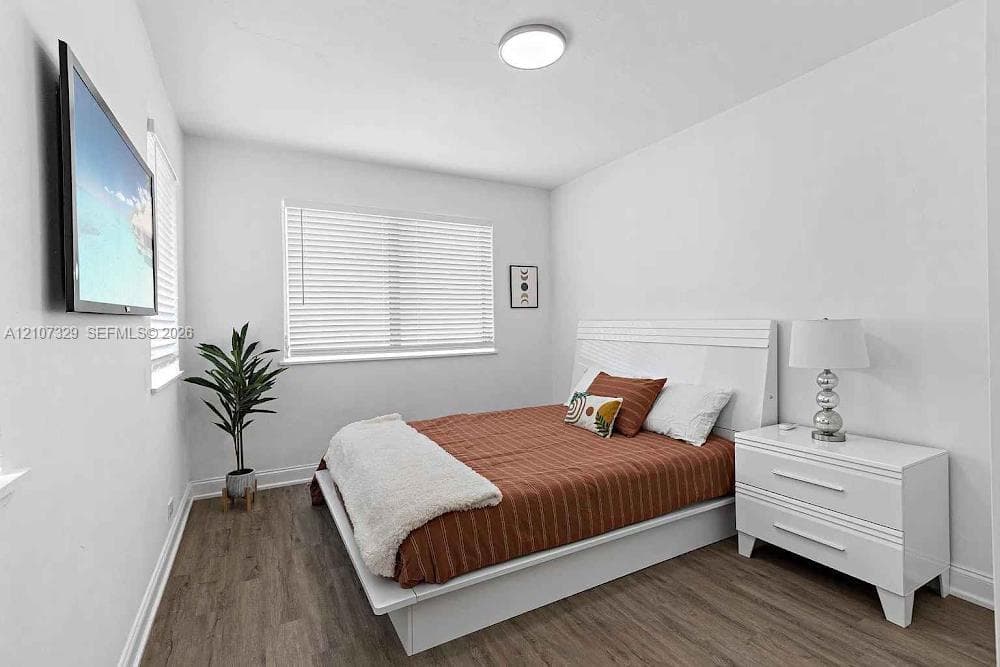 Bedroom with bed and windows with blinds.