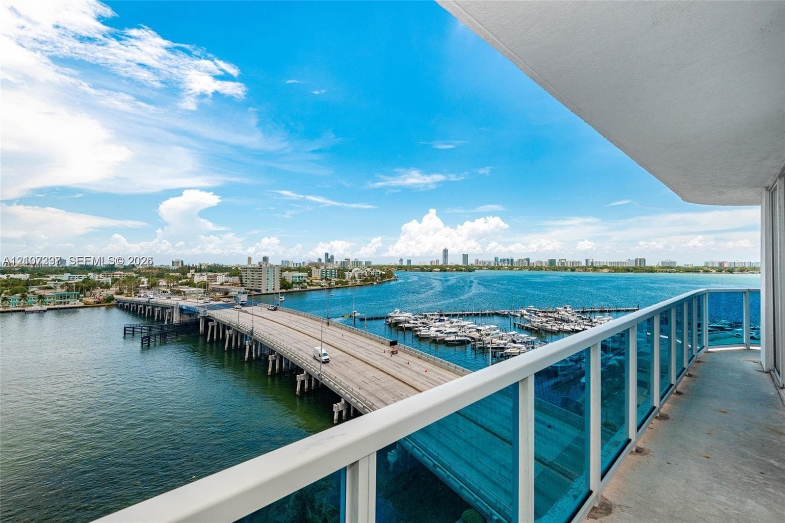 Covered balcony featuring concrete flooring and a blue-tinted glass railing