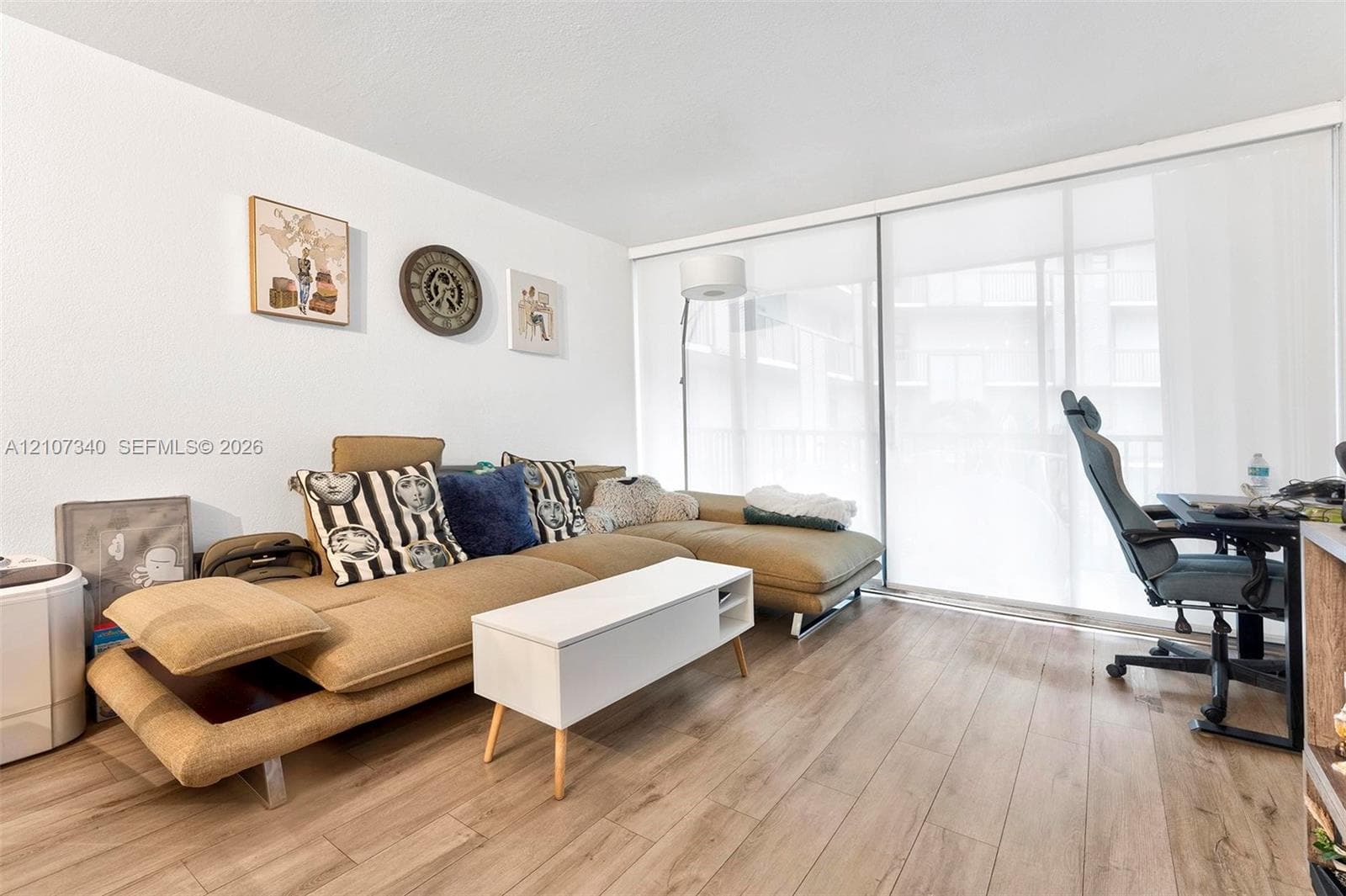 Wood-finish flooring and floor-to-ceiling sliding glass doors with integrated roller shades