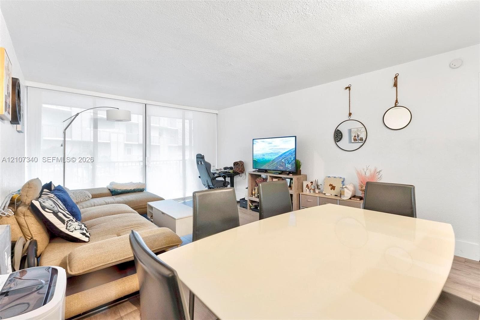 Open-concept living space featuring wood-finish flooring and large sliding glass doors providing natural light