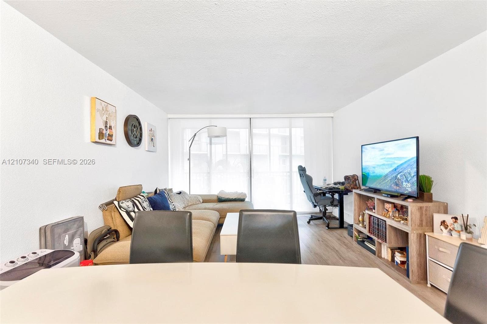 Open-concept living space featuring wood-finish flooring and a floor-to-ceiling sliding glass door