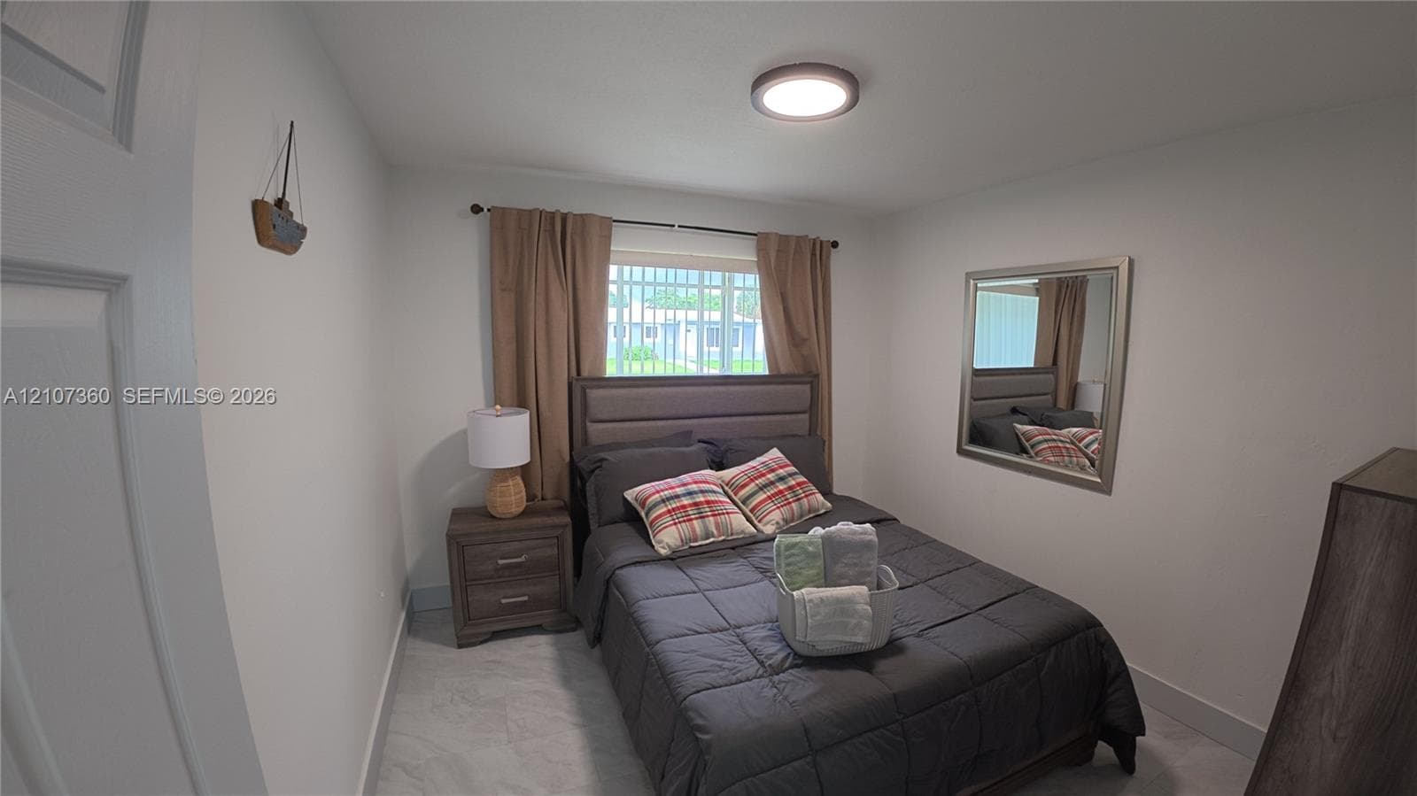Bedroom featuring a single window, neutral wall paint, tile flooring, and a flush-mount ceiling light