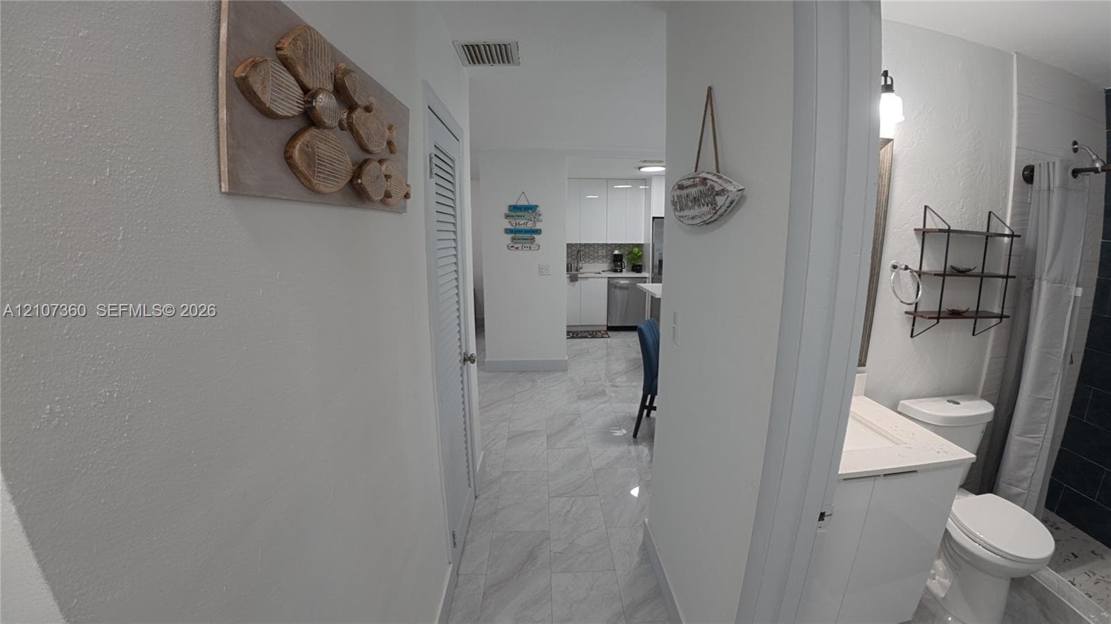 Bathroom featuring a vanity with an integrated basin, a standard-height toilet, and a tiled shower enclosure