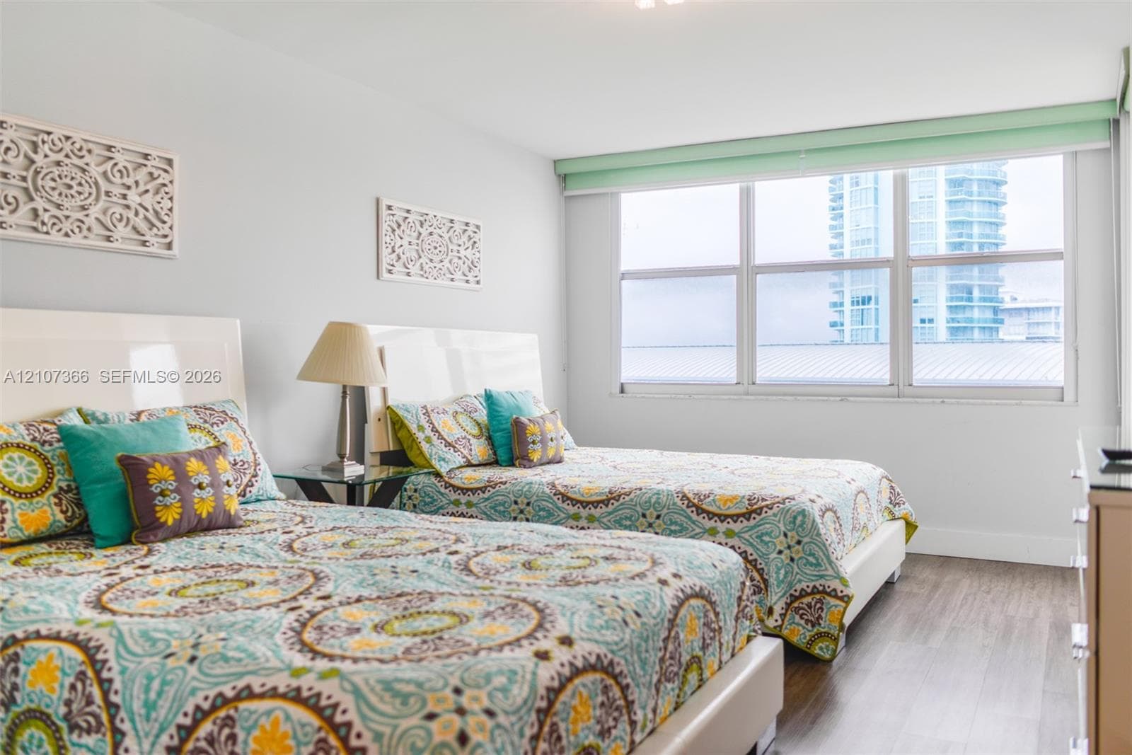 Room featuring wood-finish flooring, neutral wall tones, and large horizontal windows