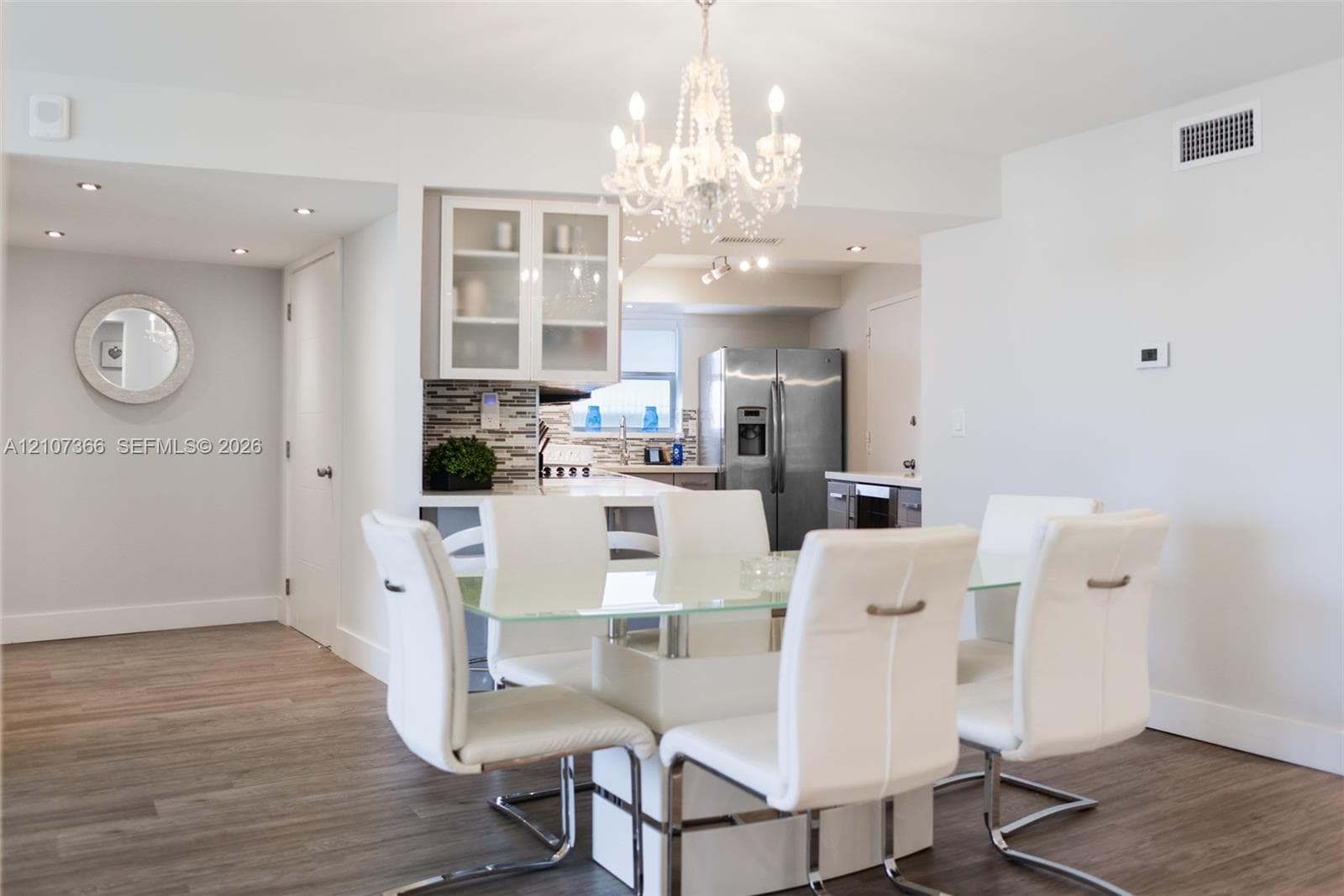 Dining area featuring wood-finish flooring, a decorative crystal chandelier, and a neutral color palette