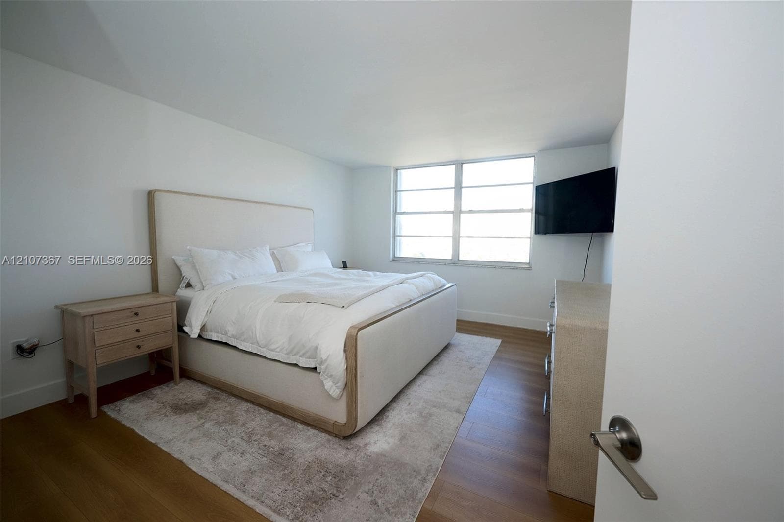 Walk-in closet featuring white built-in shelving, integrated dresser drawers, hanging rods, recessed ceiling lighting, and wood-finish flooring