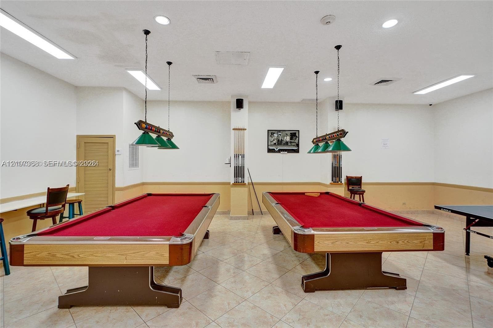 Recreational space featuring tile flooring, recessed lighting, and two built-in pendant light fixtures with green shades