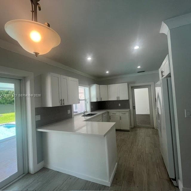 Living area featuring exposed dark-stained wooden ceiling beams, whitewashed brick fireplace with a semi-circular firebox, and wood-finish flooring with floor-to-ceiling glass panel sliding doors