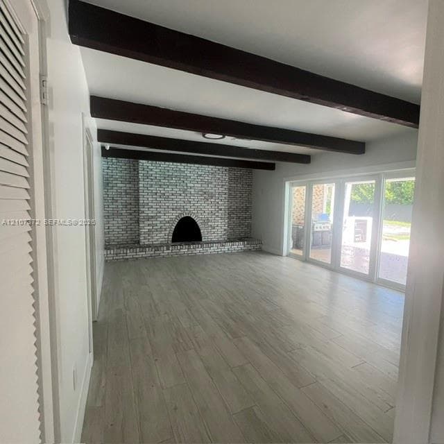 Garage space featuring an epoxy-coated floor, horizontal window with blinds, overhead light fixtures, and wall-mounted cabinetry