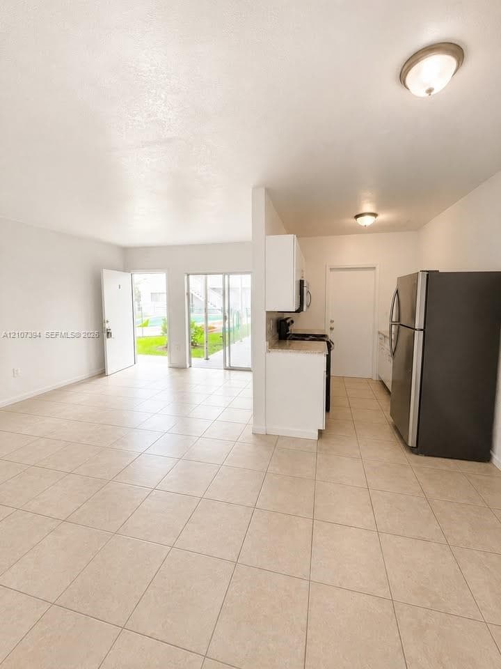 Neutral interior featuring ceramic tile flooring, horizontal window blinds, and a built-in closet with sliding doors