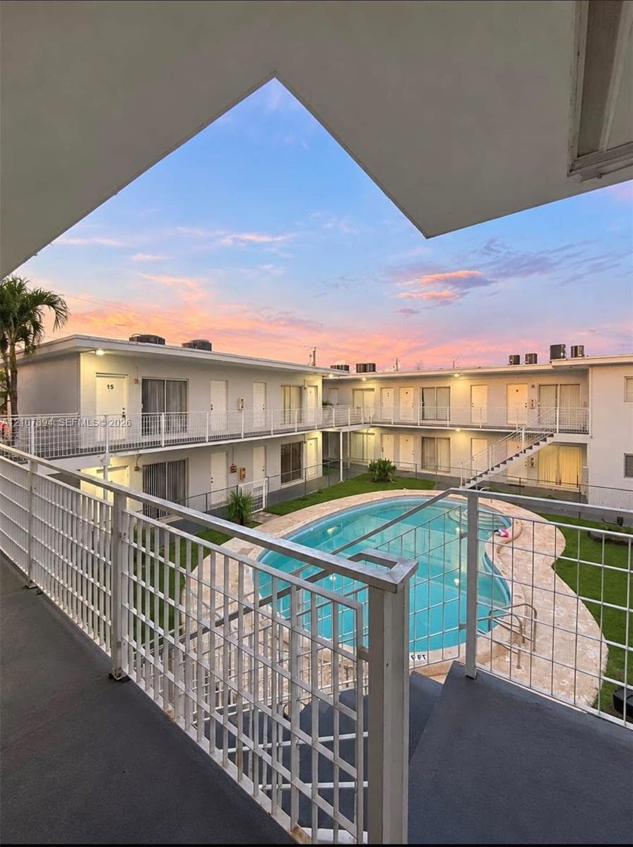 Ceramic tile flooring, white cabinetry, solid-surface countertops, stainless steel refrigerator, and glass sliding door access to exterior space