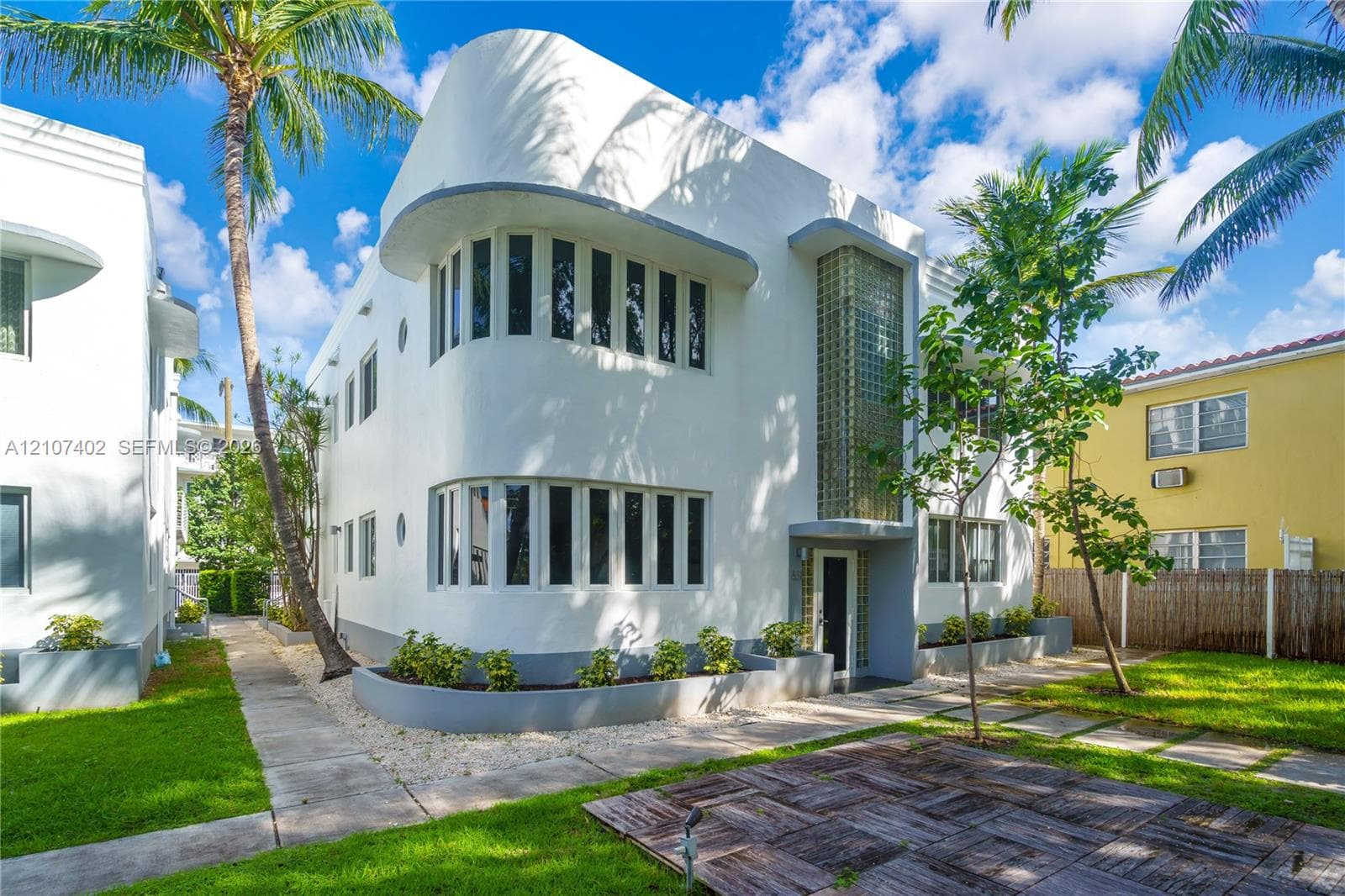 Art Deco exterior featuring curved architectural lines, smooth stucco facade, multi-pane window configuration, and vertical glass block detailing