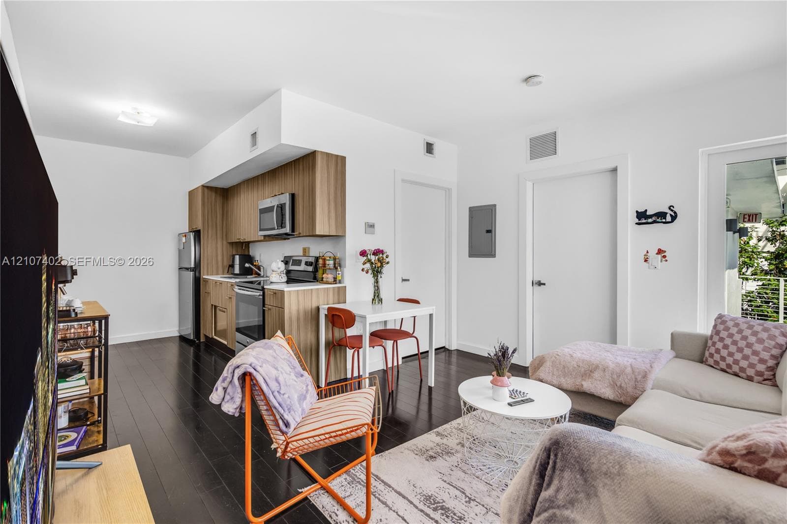 Kitchen featuring wood-finish cabinetry, stainless steel appliances, and wood-finish flooring