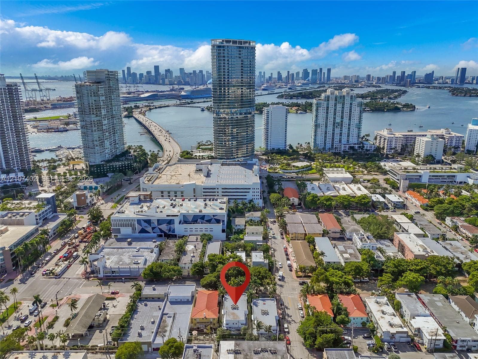 Aerial perspective of a multi-story urban property featuring a flat roofline, positioned within a densely developed metropolitan area