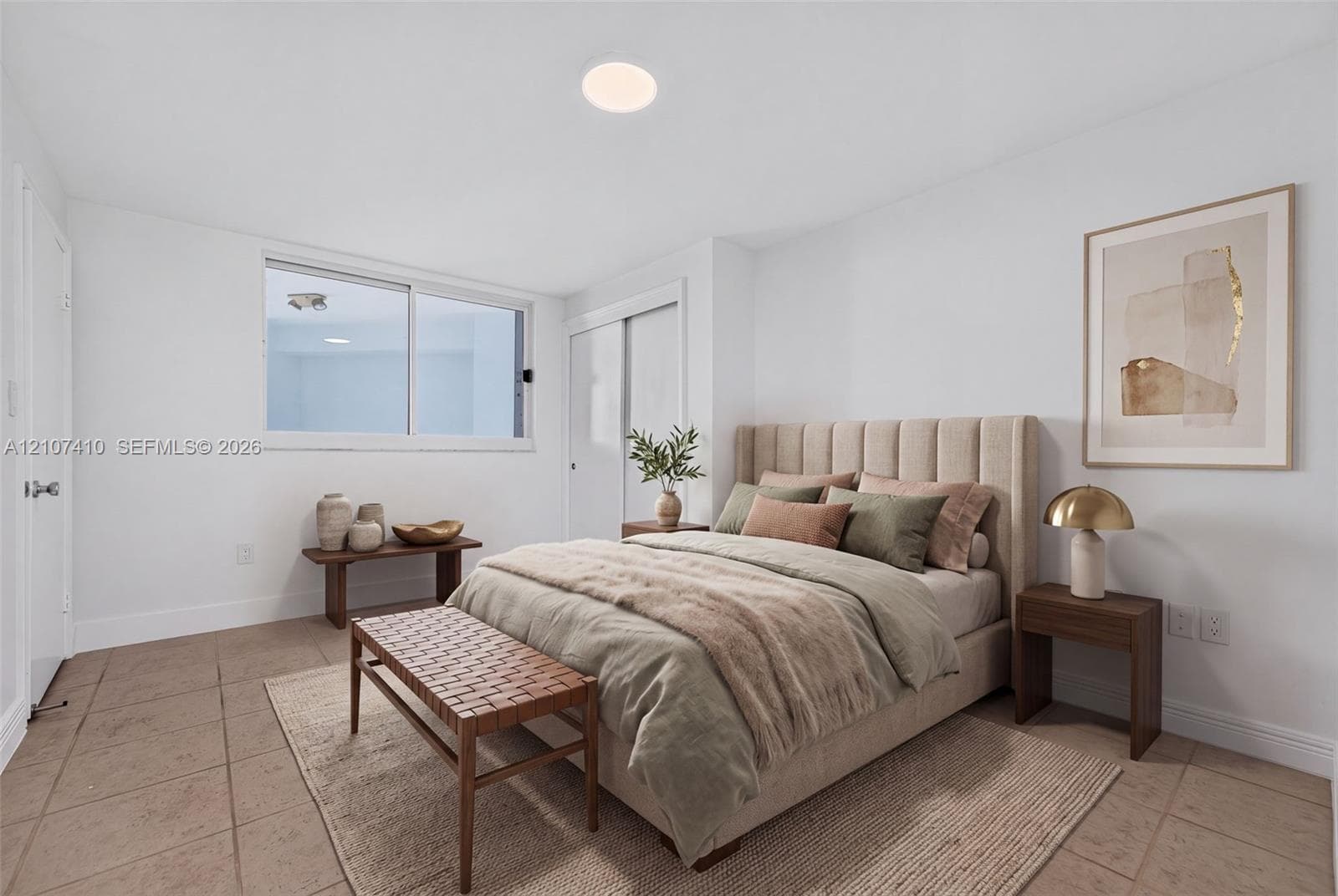 Neutral-toned ceramic tile flooring, sliding glass window, and built-in closet with sliding doors