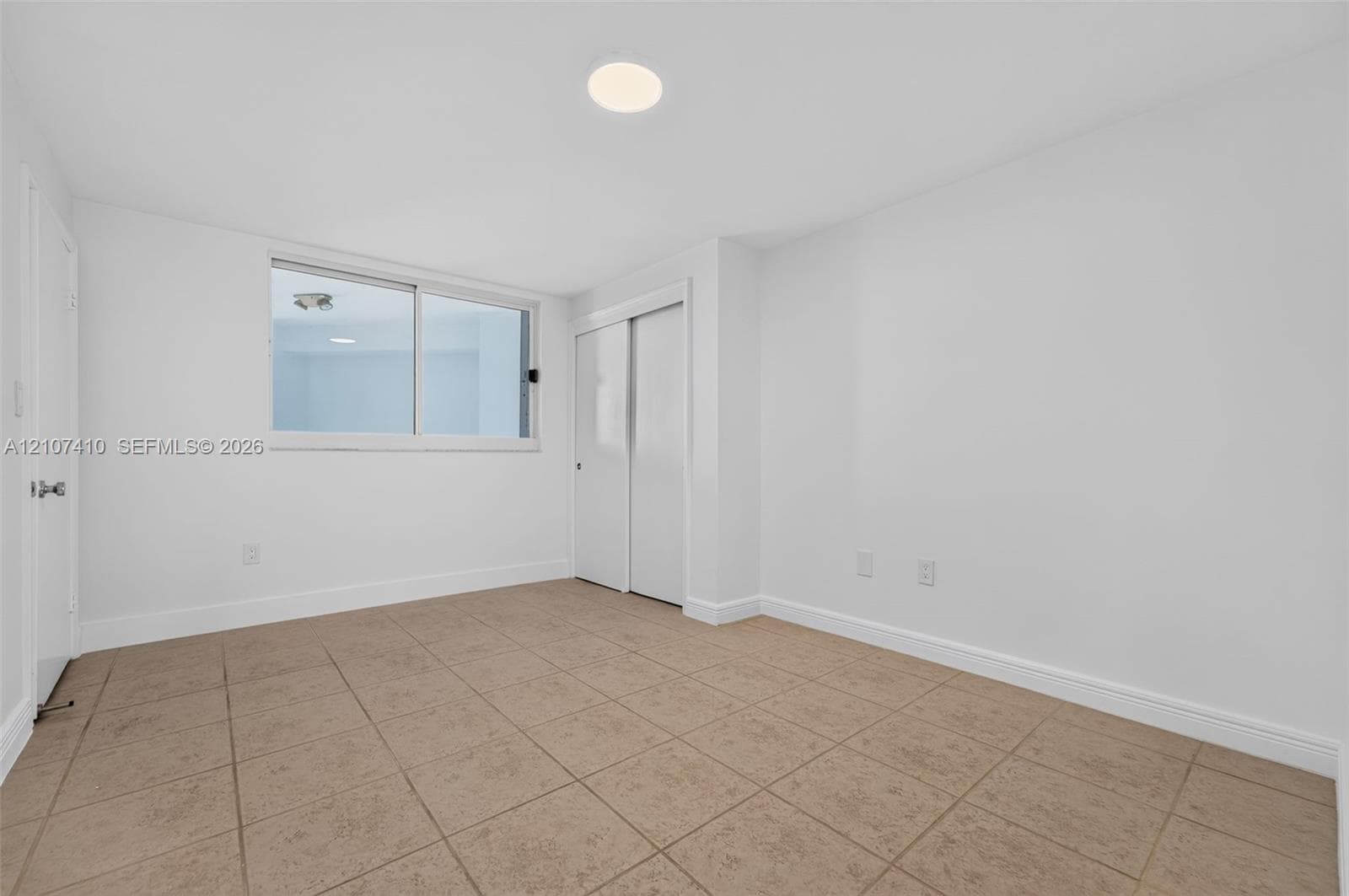 Room featuring ceramic tile flooring, sliding door closet, recessed lighting, and a dual-pane sliding window