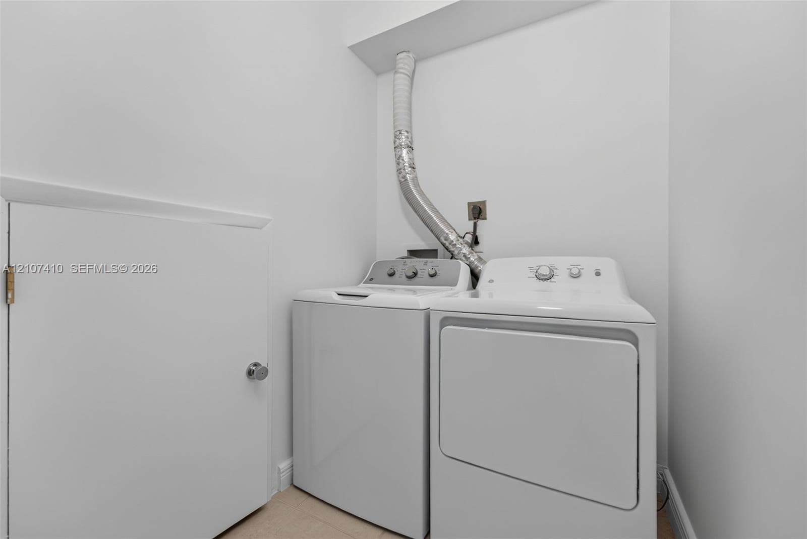 Dedicated laundry area featuring a top-load washer, a front-load dryer, and an integrated storage closet